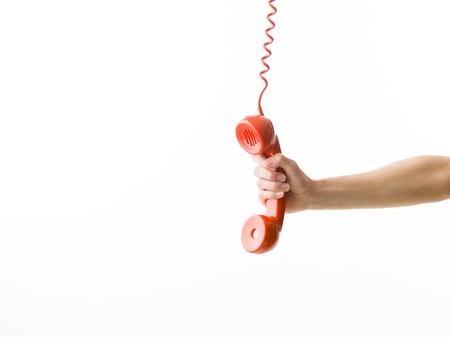female hand holding telephone receiver against white background
