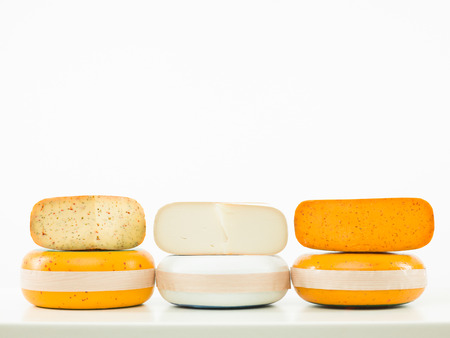 three kinds of cheese arranged in line on white backgroundの写真素材