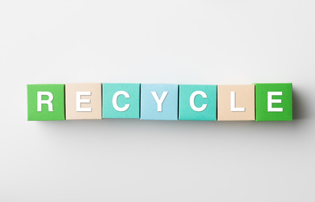 multicolored paper blocks with recycle word written on them, on white background. copy space availableの写真素材