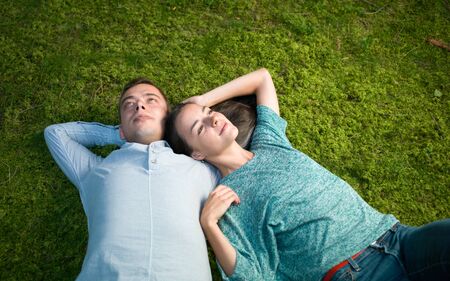 young couple lying on green moss , relax enjoying nature
