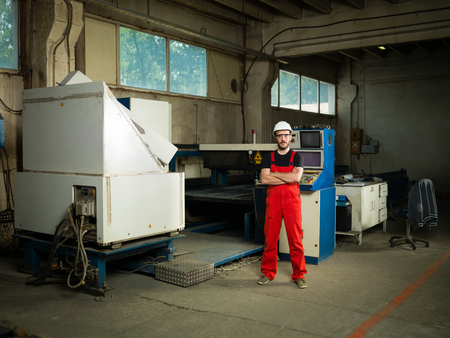 view of a man looking happy and proud, with his arms crossed over his chest, wearing red overalls,...