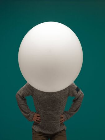 funny young man huge balloon on blue background. head - balloonの写真素材
