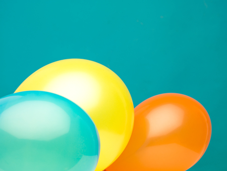 clean landscape composition made from three balloons aquamarine, yellow, and orange against a cyan backgroundの写真素材