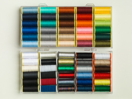 multi colour thread rolls arranged in a plastic boxの写真素材