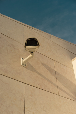 Surveillance camera on building with blue skyの写真素材