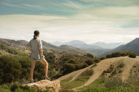 Young woman looking forward to reach the Sierra Nevada Mountain peak in southern Spainの写真素材