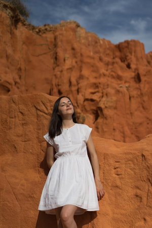 Woman on orange background, enjoying the sun, eyes closedの写真素材