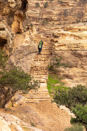 PETRA, JORDAN- JANUARY 13,2020: unidentified backpackers walks the steps of a staircase in the ancient city of Petra, where many staircases, carved in the mountains, lead to temples and tombsのeditorial素材