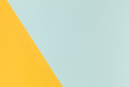 Light blue and yellow pastel color paper geometric flat lay backgroundの写真素材