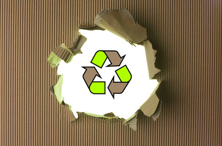 Ripped brown paper with recycle logo against backgroundの写真素材