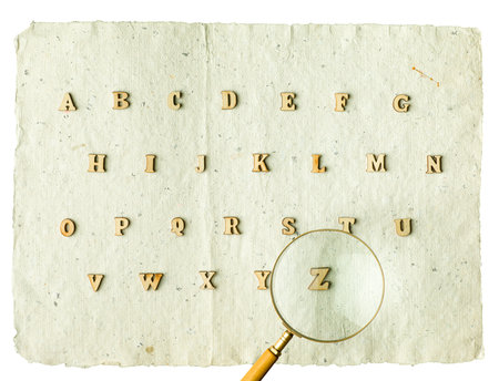 Wooden alphabet blocks with letters. Vintage magnifier on top.の写真素材
