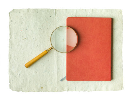 Recycled cream, grey vintage horizontal note paper texture. Vintage magnifier on top of a notebook.の写真素材