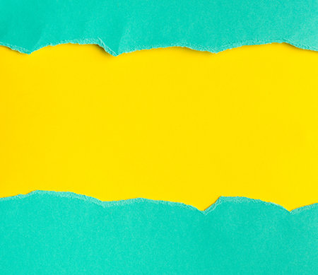 Upper and lower part of ripped open paper, aqua on yellow backgroundの写真素材