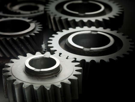 Industrial gears and cogs on black background