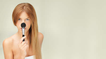 beautiful woman with blusher brush on noseの写真素材