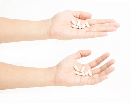 Medicine in a hand on white backgroundの写真素材