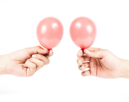 Hand holding colorful helium balloons isolated on white backgroundの写真素材