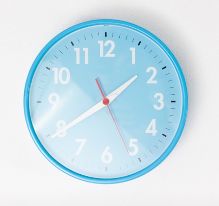 A blue wall clocks on white groundの写真素材