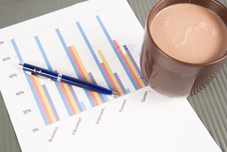 Close-up image of an office desk at morning with a cup of tea and financial documentsの写真素材
