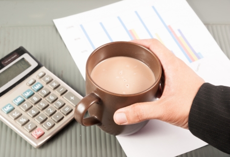 Close-up image of an office desk at morning with a cup of tea and financial documentsの写真素材