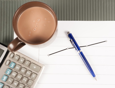 Close-up image of an office desk at morning with a cup of tea and financial documentsの写真素材