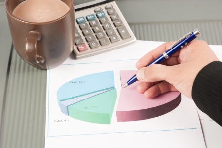 Close-up image of an office desk at morning with a cup of tea and financial documentsの写真素材