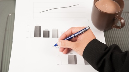 Close-up image of an office desk at morning with a cup of tea and financial documentsの写真素材