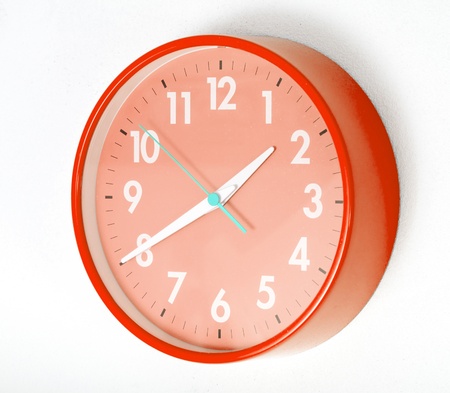 A red wall clocks on white groundの写真素材