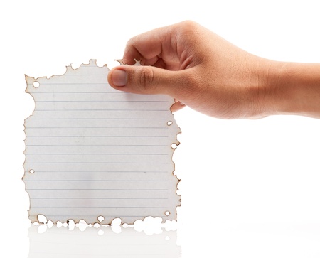 Hand holding piece of burned paper on white background.の写真素材