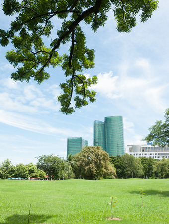 modern apartment building with green grass and blue skyの写真素材