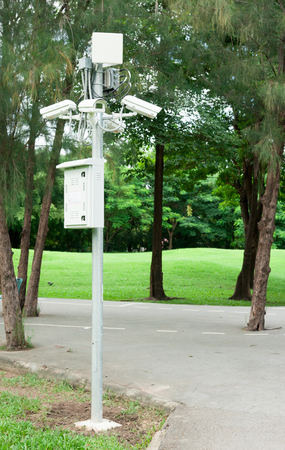 Security surveillance camera near green forestの写真素材