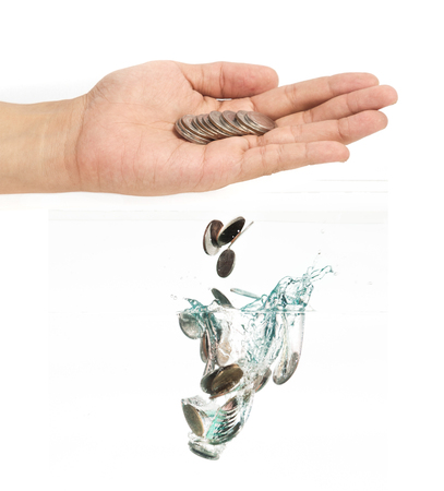 coins falling into the clear waterの写真素材