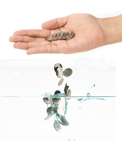 coins falling into the clear waterの写真素材
