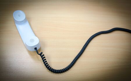 Elevated View of a white Telephone Receiver on a wooden table,の写真素材