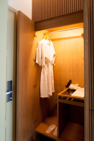 Close up of clothes hanger and twins bathrobe in wooden wardrobe in hotelの写真素材