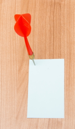 Red darts in an empty or blank notepad on a vintage wooden boardの写真素材