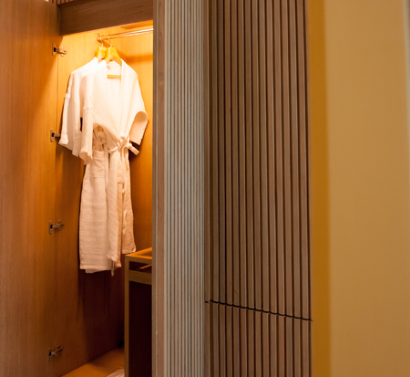 Close up of clothes hanger and twins bathrobe in wooden wardrobe in hotelの写真素材