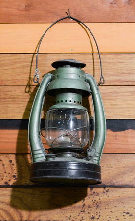 Old lantern and saw hanging on a shed.の写真素材