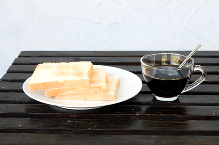 plate with a cup of coffee and breadの写真素材