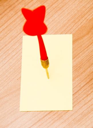 Red darts in an empty or blank notepad on a vintage wooden boardの写真素材