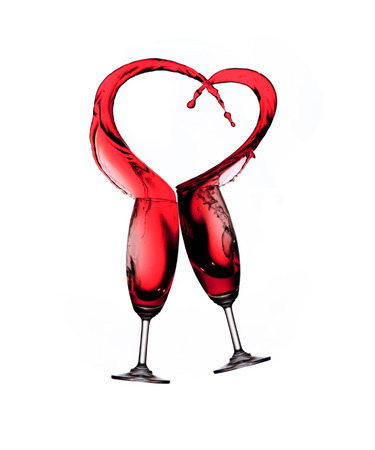 Heart splash from two glasses of red wine isolated on white backgroundの写真素材