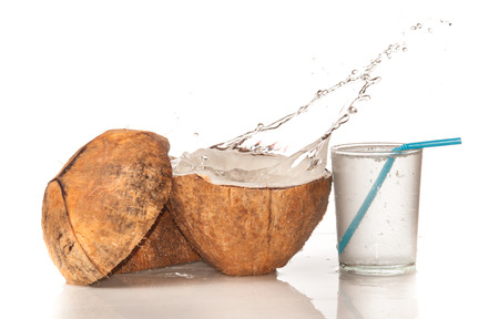 Coconut with water splash over whiteの写真素材