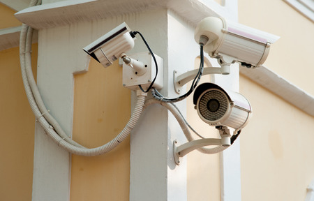 Three Security cameras frontal view on concrete wall