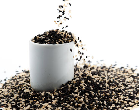 black and white sesame seeds isolated on white backgroundの写真素材