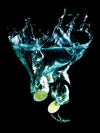 coins falling down to waterの写真素材