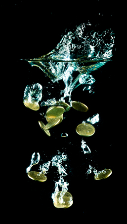 coins falling down to waterの写真素材
