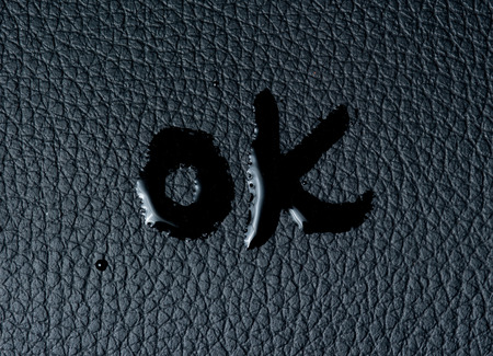 The word "OK" on black skinの写真素材