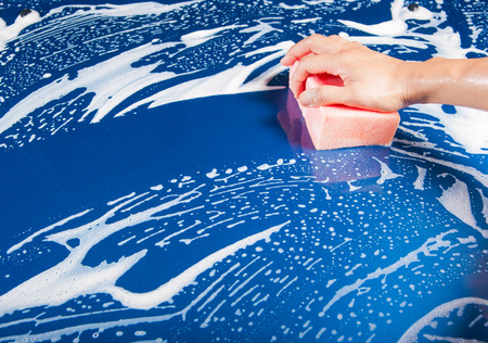 hand hold sponge over the car for washingの写真素材