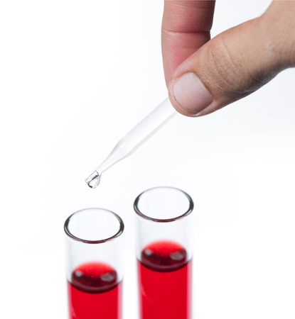 liquid dripping from pipette into test tube isolatedの写真素材