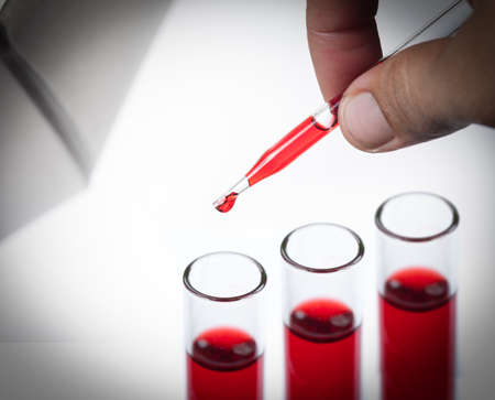 liquid dripping from pipette into test tube isolatedの写真素材